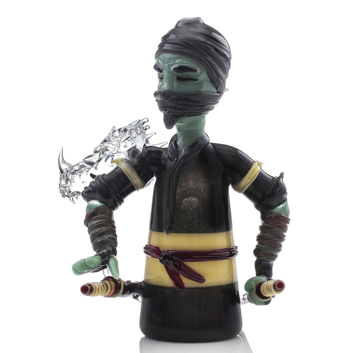 Studio Photo of the Alien Ninja Warrior Heady glass piece made by R3G15, ninja has two swords in sheaths at hip and clear animal skull armor on his right shoulder. 