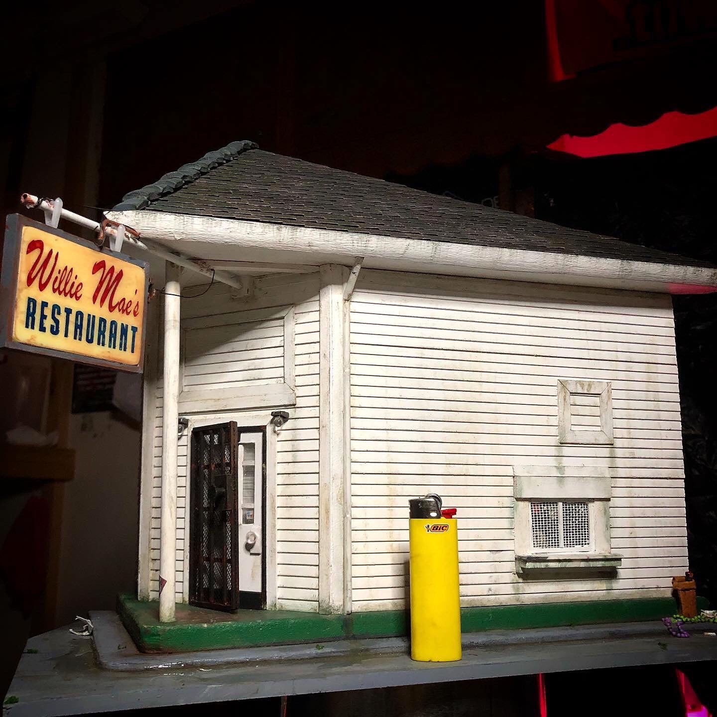 Photo showing the entire Willie Mae's Restaurant Miniature model from the front right view, there is a yellow bic lighter for scale which is about one fifth of the height of the model. 
