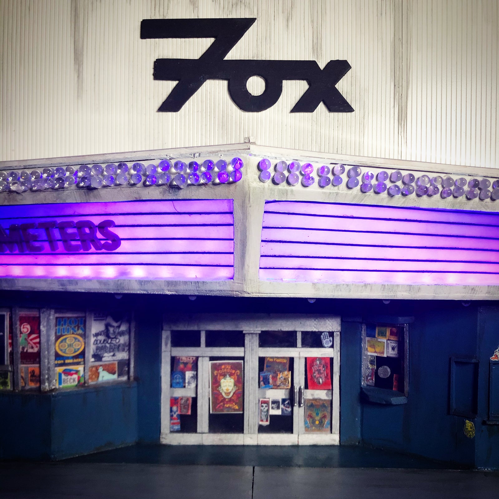 Close up photo of the Fox Theater miniature model, showing the front of the theater lit up and the overhead sign with iconic font.