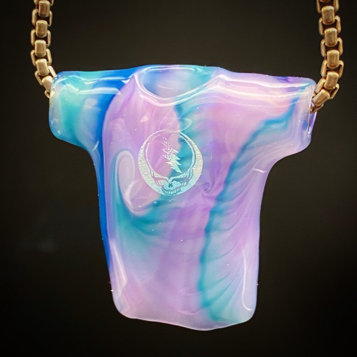 Purple and Light Blue Tie Dye Tech glass pendant shown on a black background hanging from a silver box chain. 