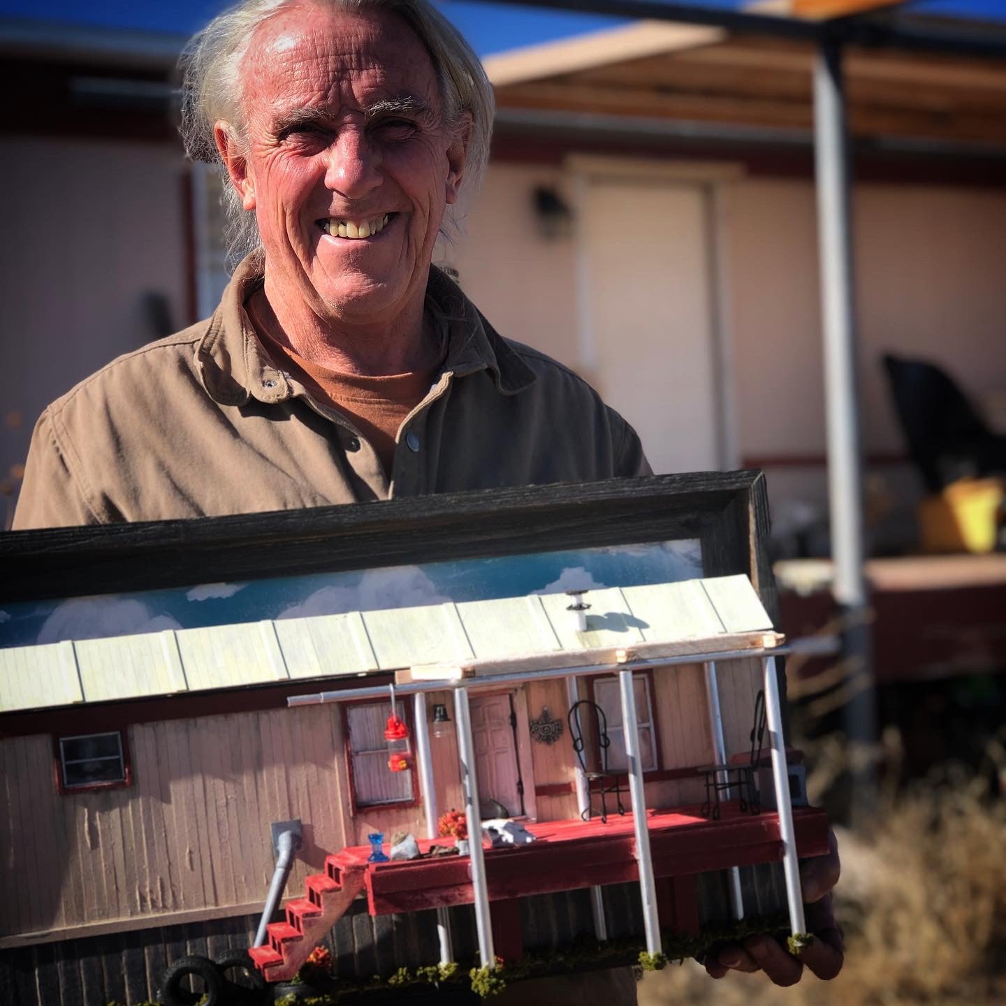 Collector holding his miniature commission, photo is taken outdoors with a building in background. 