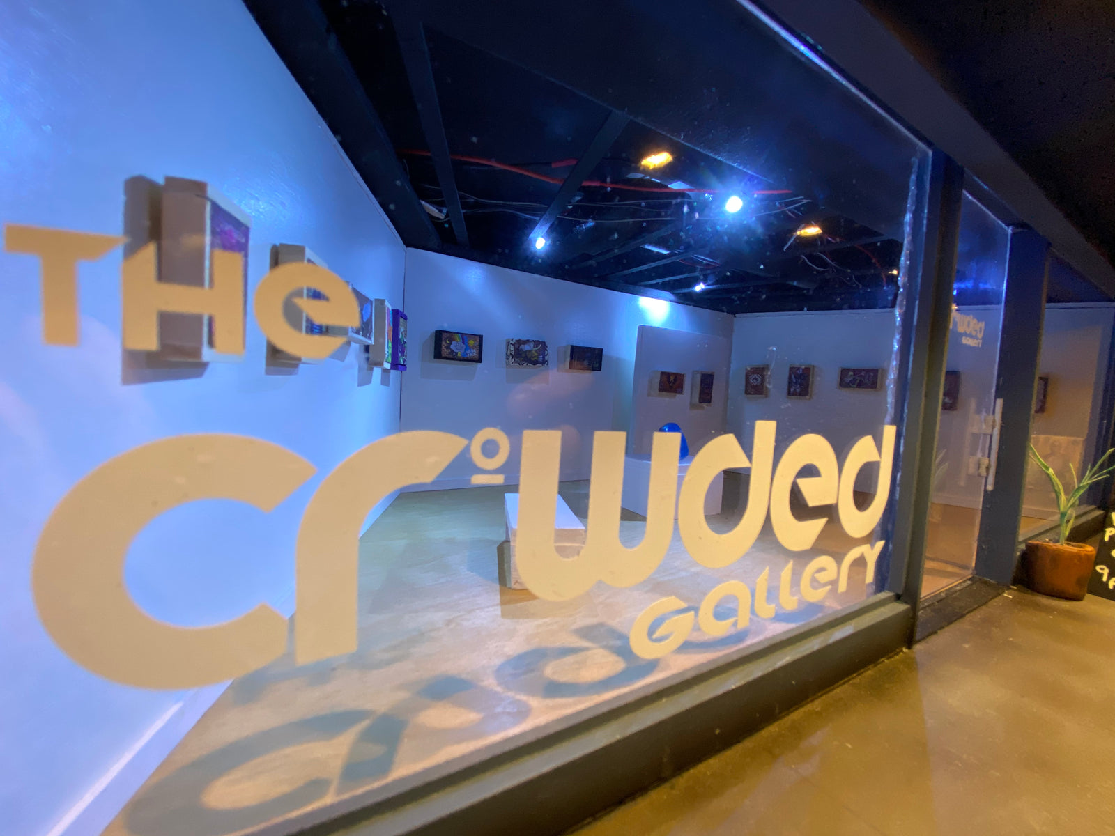 Close up view though the window of the Crowded Gallery miniature model, showing the art on the walls and the window decals. 