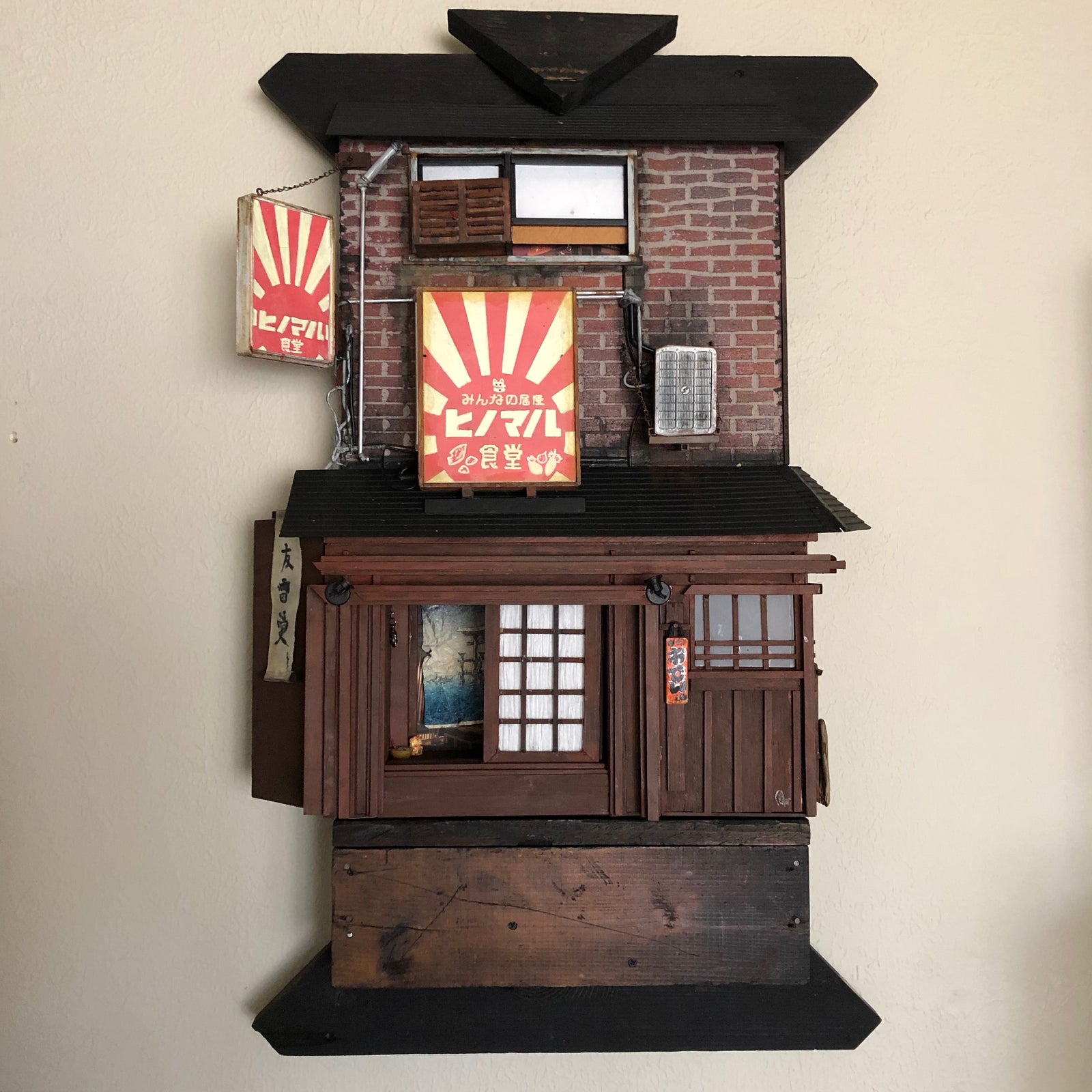 Sushi restaurant miniature model shown hanging on wall. 