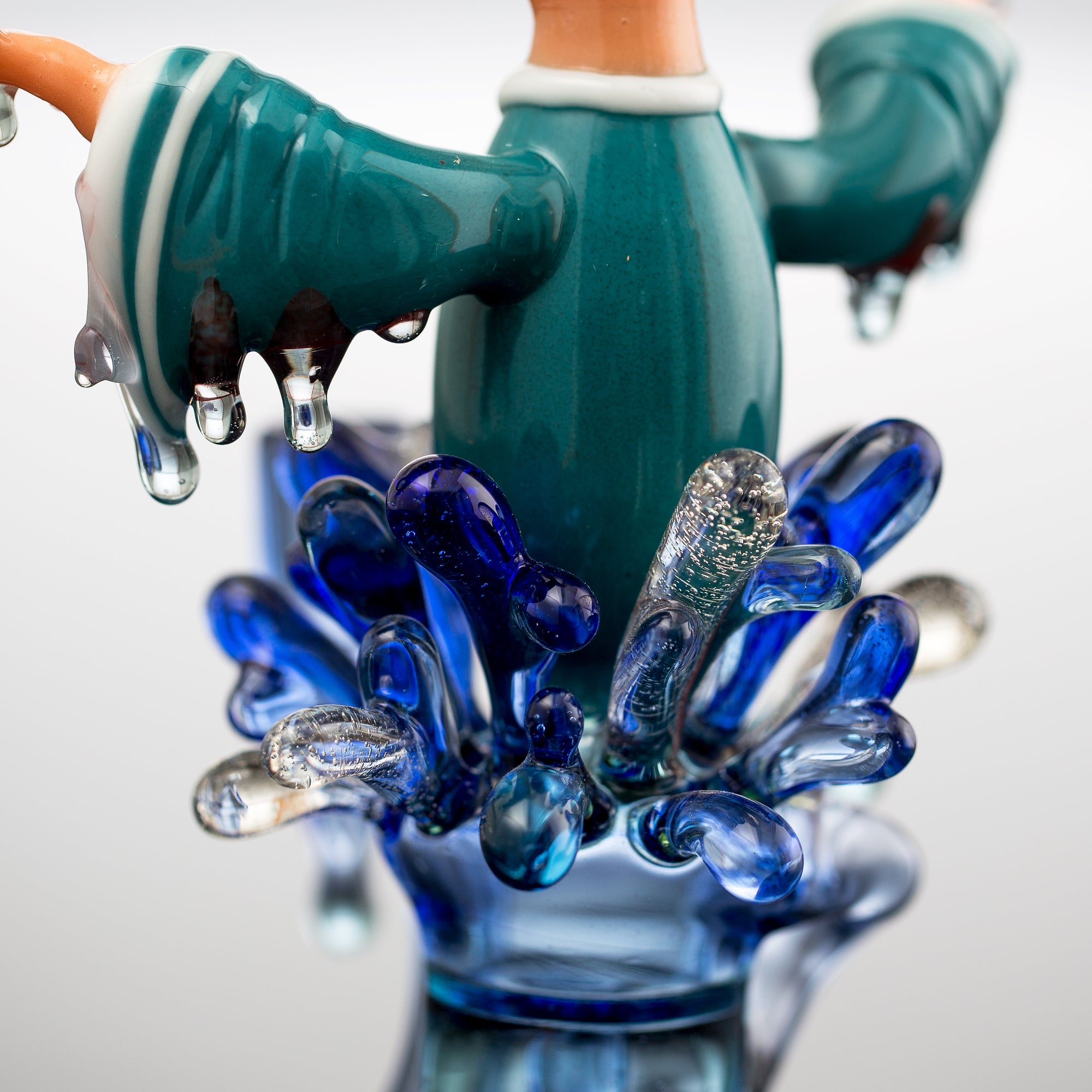 Close up studio photo of R3G15 x Burtoni Water Monk collab showing glass water splashes around the monk waist and mid section. 
